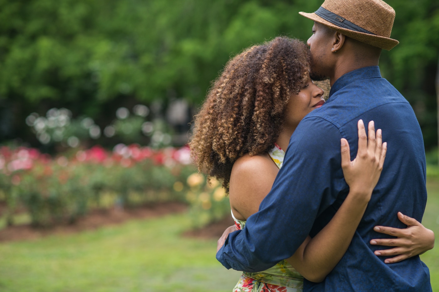 man kisses woman's forehead during Raleigh Rose Garden portrait session