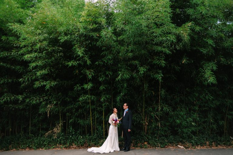 bride and groom stand by bamboo in UGA Founders Garden