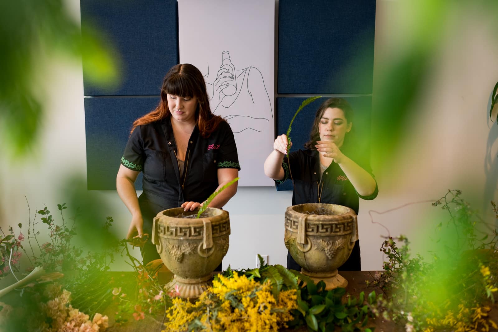 woman works on eco-friendly floral arrangement in pot